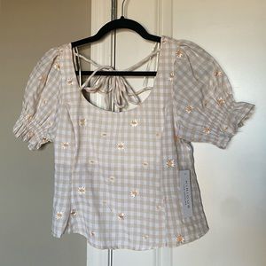 Beige and white gingham patterned shirt with small daisies on it; Tie in back